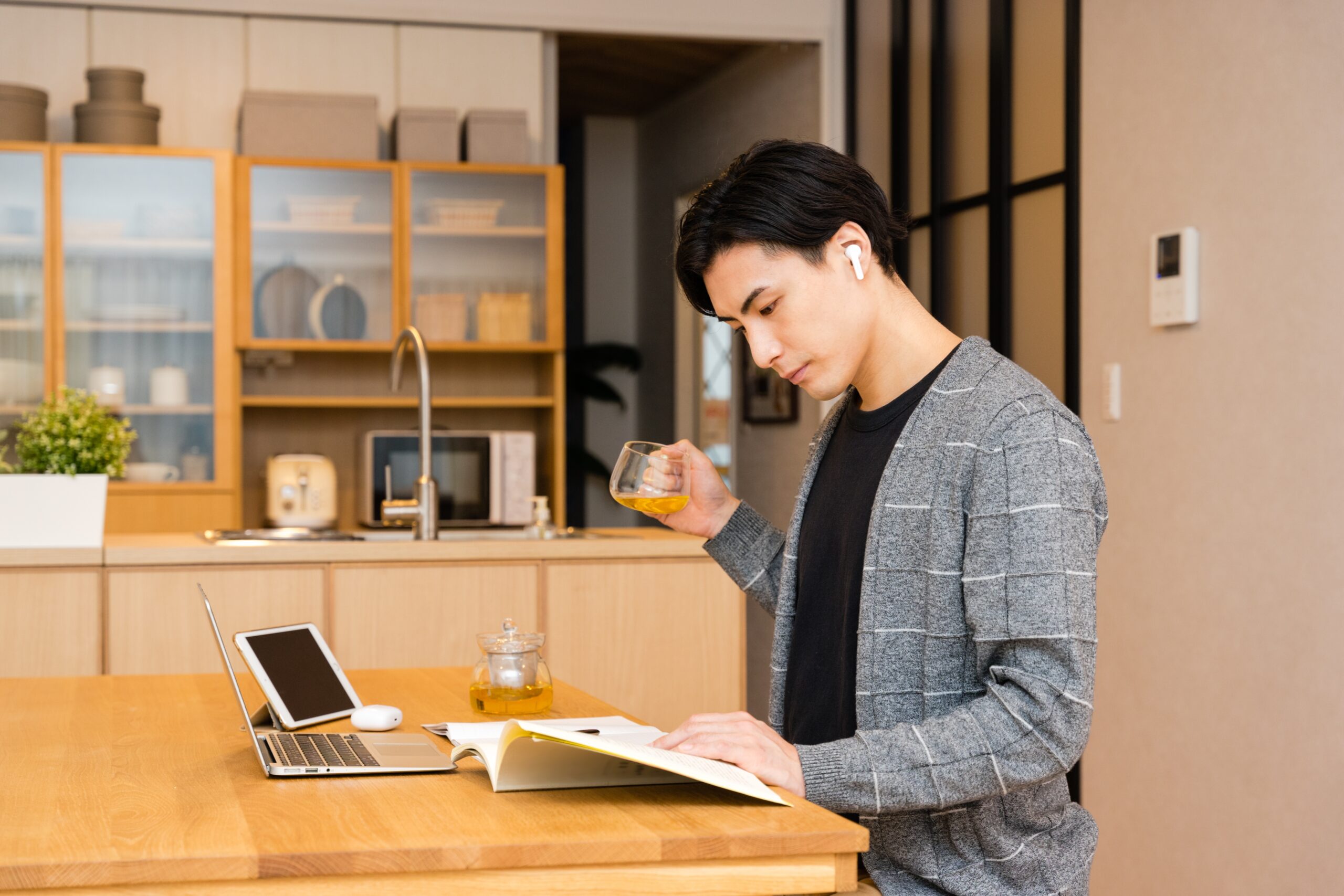 紅茶を飲みながら自宅で勉強する男性
