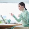 オンライン英会話を受ける緑色の服を着た女性