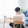 自宅でオンライン英会話レッスンを受ける私服の若い男性