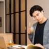自宅でお茶を片手に勉強する若い男性