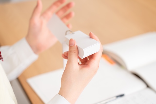 暗記カードを使って勉強する女子高校生