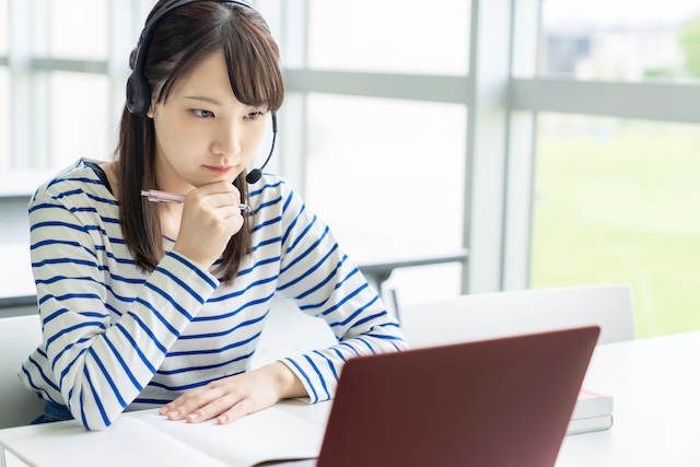 オンライン英会話のレッスンを受ける私服の女子高校生