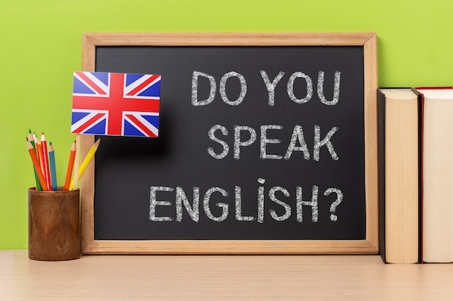 黒板に書かれたあなたは英語を話せますかの文字とイギリス国旗