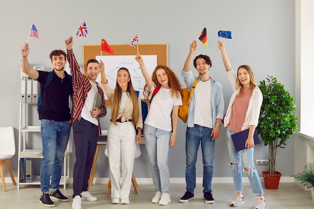 各国の国旗を掲げる外国人の学生たち